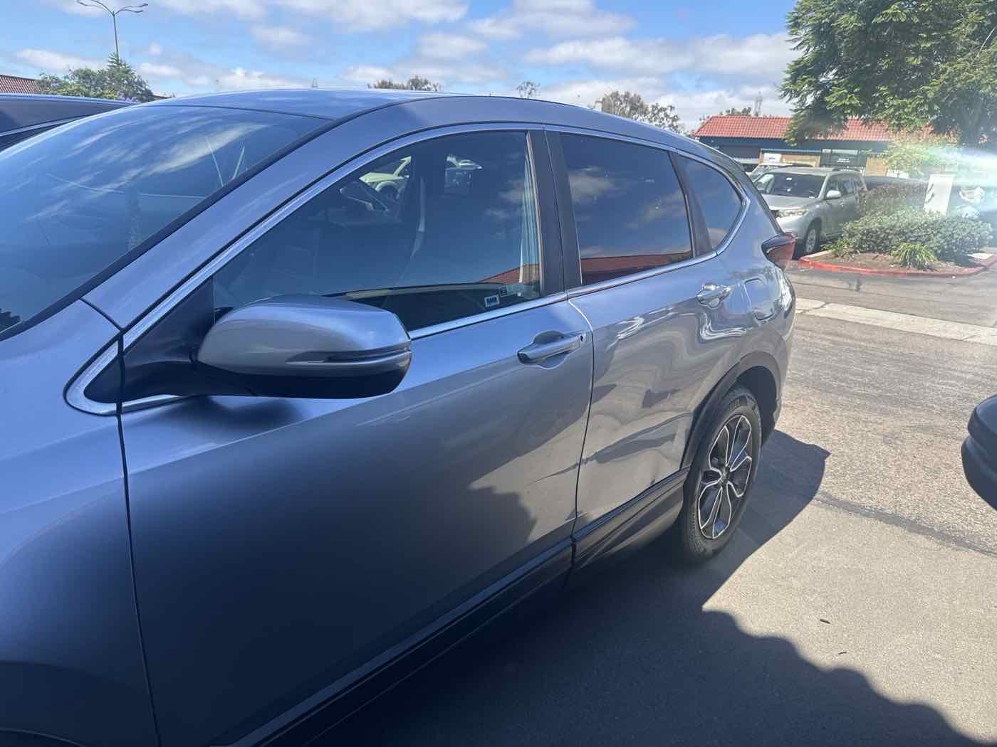 Shallow dents along the doors of a parked SUV