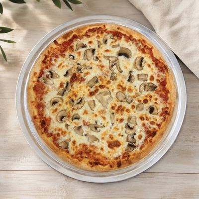 A pizza seen from above on a steel pan, sliced mushrooms over mozzarella and red sauce.
